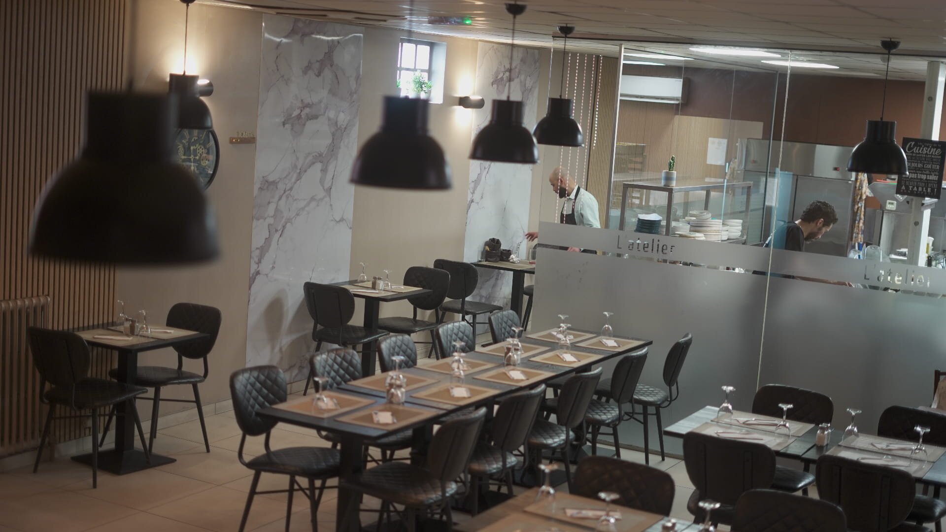 Salle principale du restaurant L'Atelier à Mantes-la-Jolie, cuisine ouverte